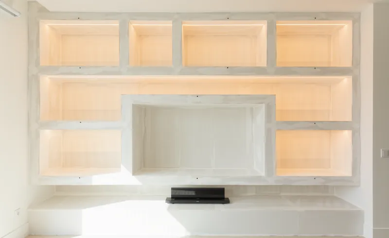Pared de pladur en fase de obra: estructura de perfiles y placas con los huecos del mueble todavía sin terminar